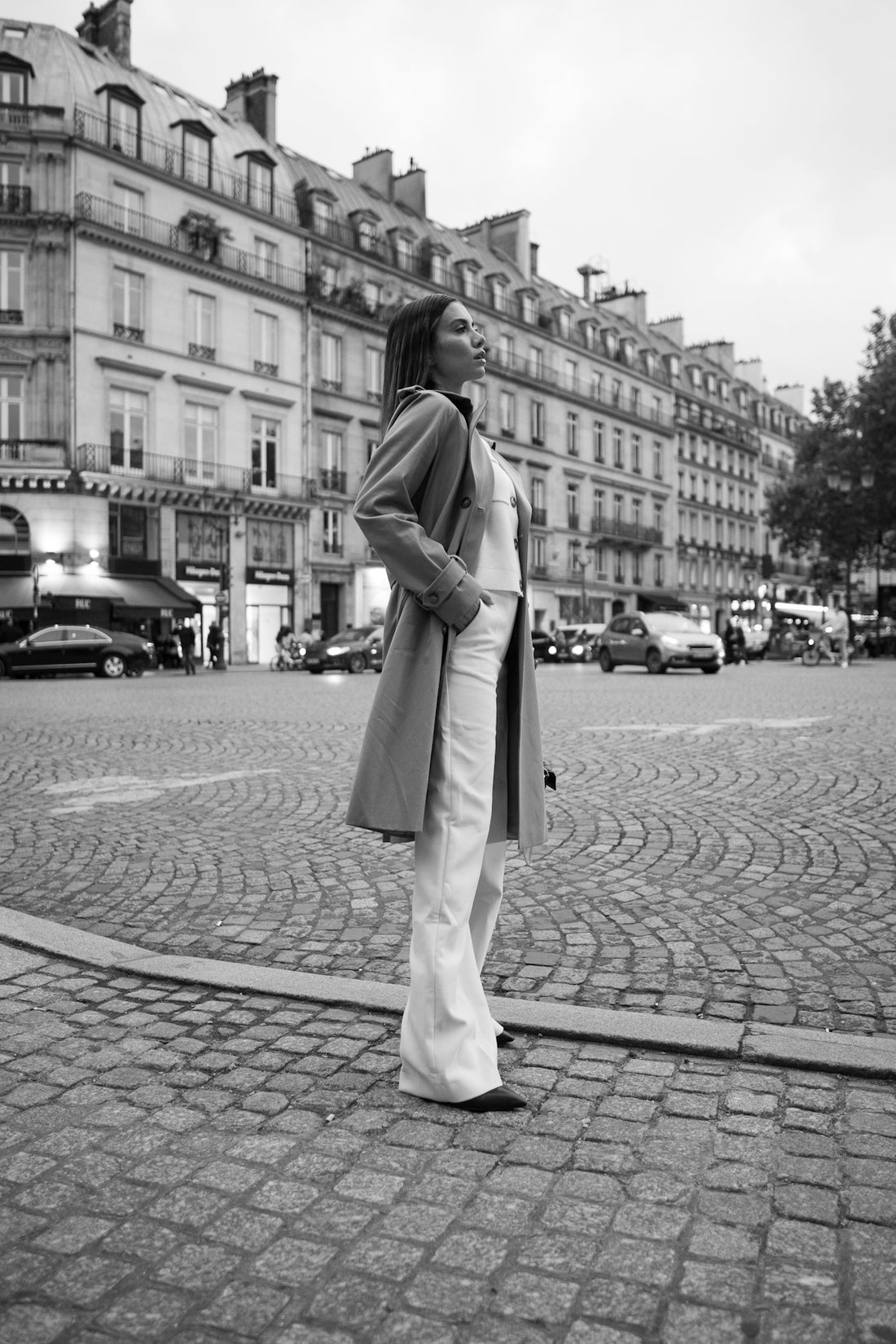 A woman standing on a cobblestone street