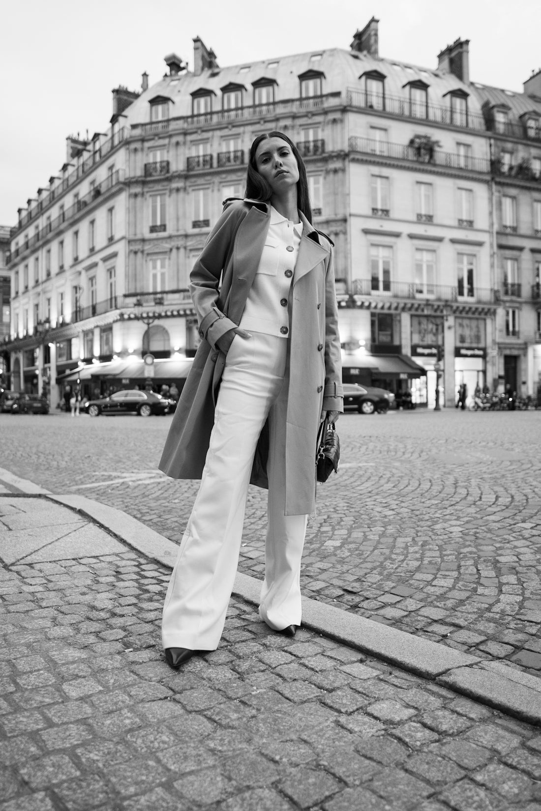 A woman standing on a brick road in front of a building